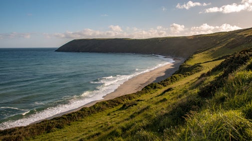 The grassy bank and beach along Dodman Point in Cornwall